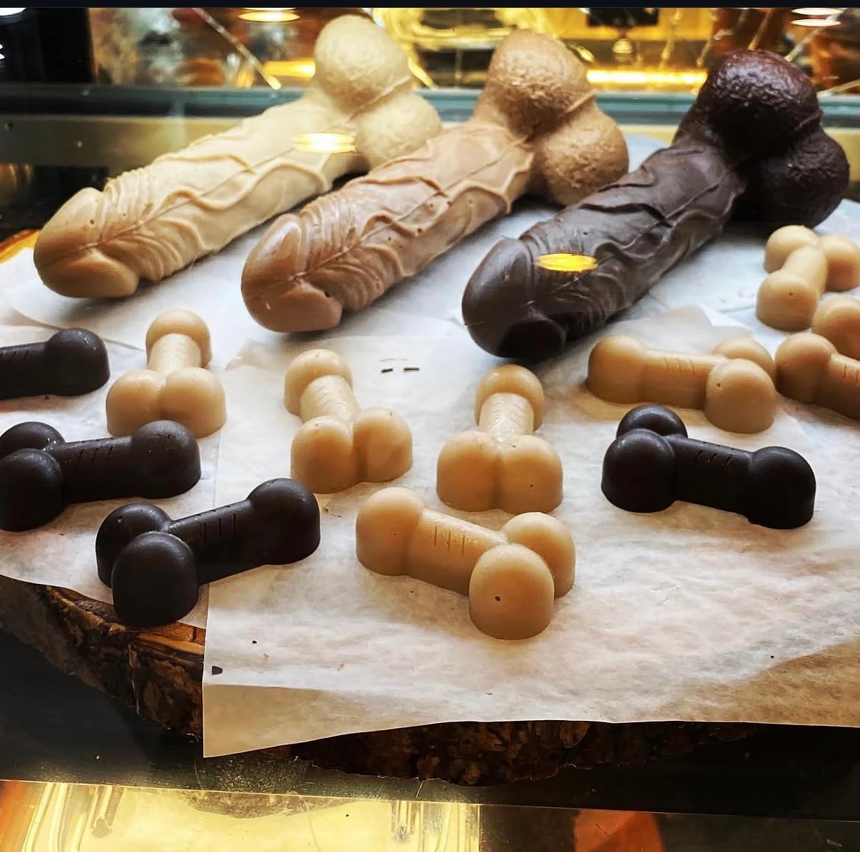 Assorted dark, milk and white penis-shaped chocolates in the display case