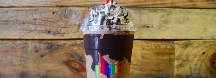 Nutella White Chocolate Mocha in a crown-branded cup with whipped cream and chocolate drizzle against a wood-plank backdrop